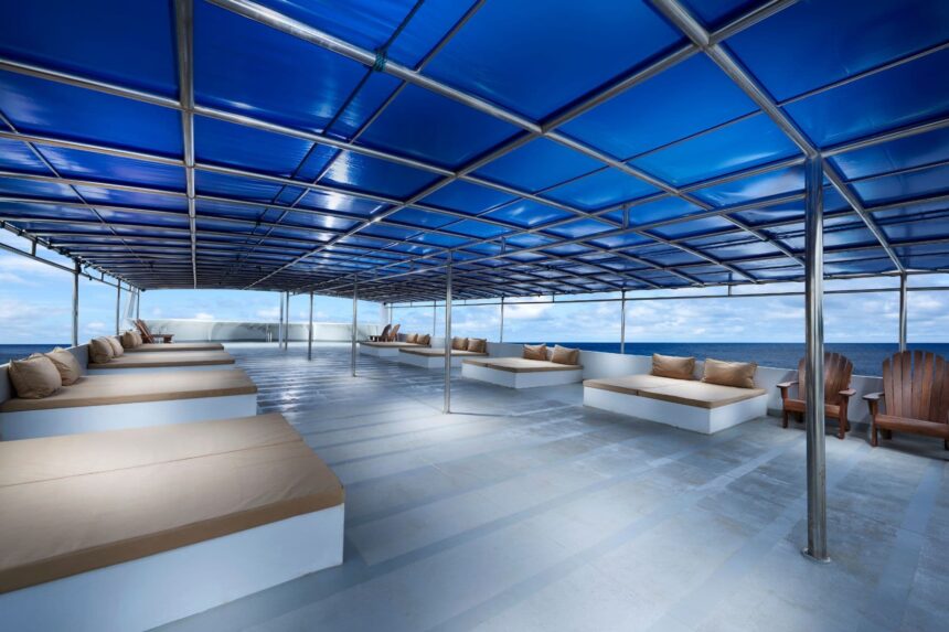 Covered sun deck with cushioned loungers on the White Manta
