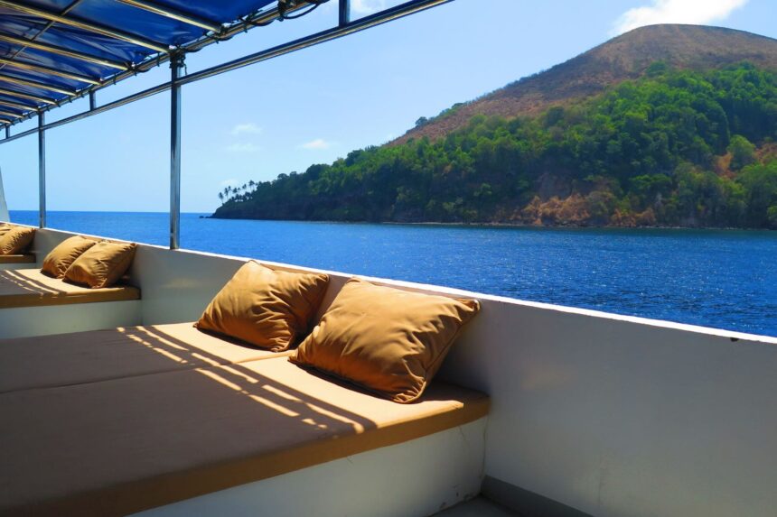 Cushioned deck seating on the White Manta overlooking a green island coastline