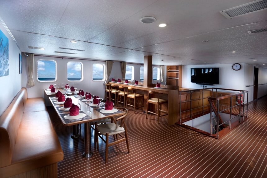Formal dining room on the White Manta set with red napkins and a bar counter