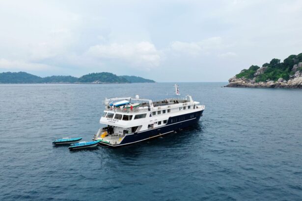 The White Manta liveaboard anchored near a rocky green island with tender boats alongside