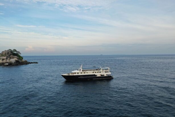The White Manta liveaboard cruising past a small rocky islet at dusk