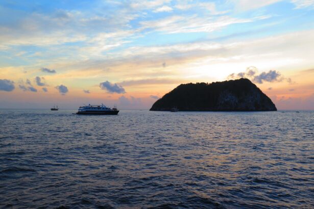 Sunset over the water with the White Manta and a rocky island silhouetted in the distance