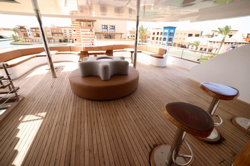 shaded upper deck with a wicker coffee table and bar stools