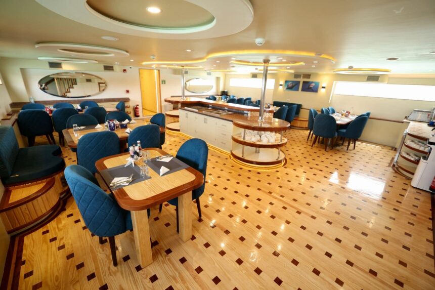 dining room with wooden tables set for guests aboard the liveaboard