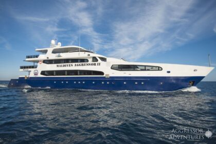 Maldives Aggressor II liveaboard underway with its name across the white superstructure