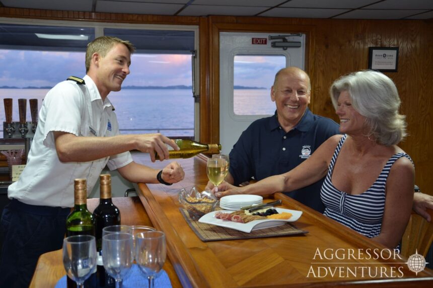Crew member pouring wine for guests at the bar on the Palau Aggressor II