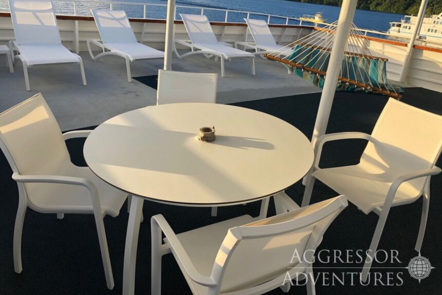 Outdoor dining table and lounge chairs on the sundeck of the Palau Aggressor II