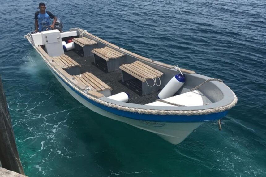 Small wooden dive tender boat waiting at a jetty in Indonesia