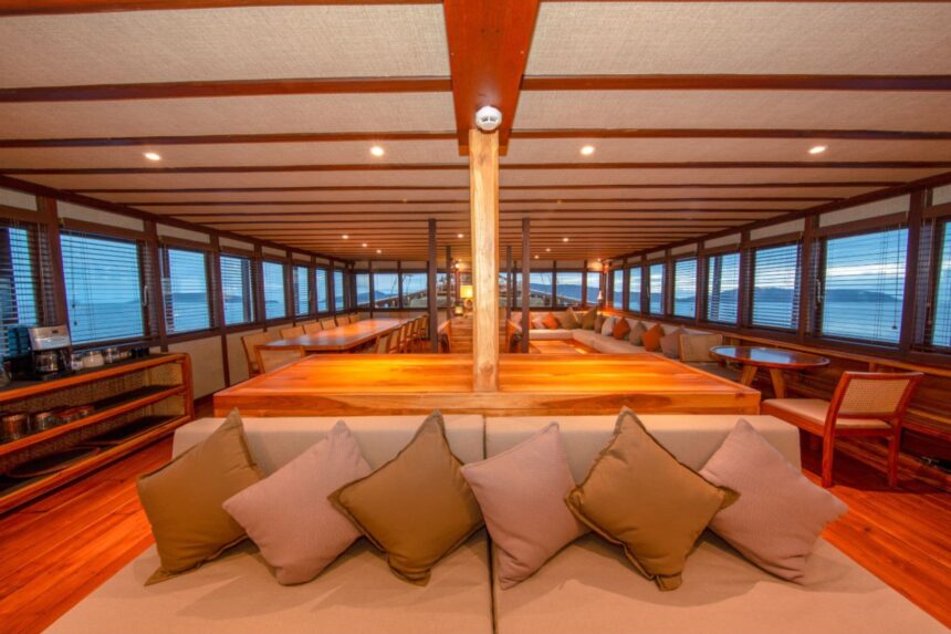 Indoor lounge and dining salon aboard the Coralia liveaboard at dusk