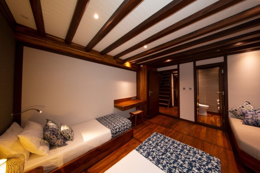 Twin cabin aboard the Coralia with wood paneling and en-suite bathroom