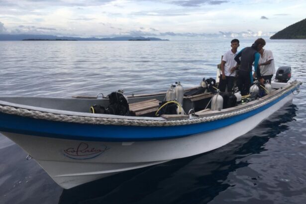 Dive tender loaded with scuba tanks and crew on calm water at dusk