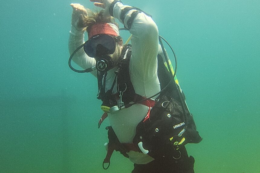 Our tester reaching overhead underwater to check range of movement in the Aqualung Axiom i3+