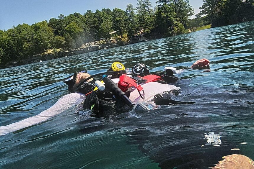 DIVEIN testers floating at the surface of a quarry lake in full scuba gear before dropping down