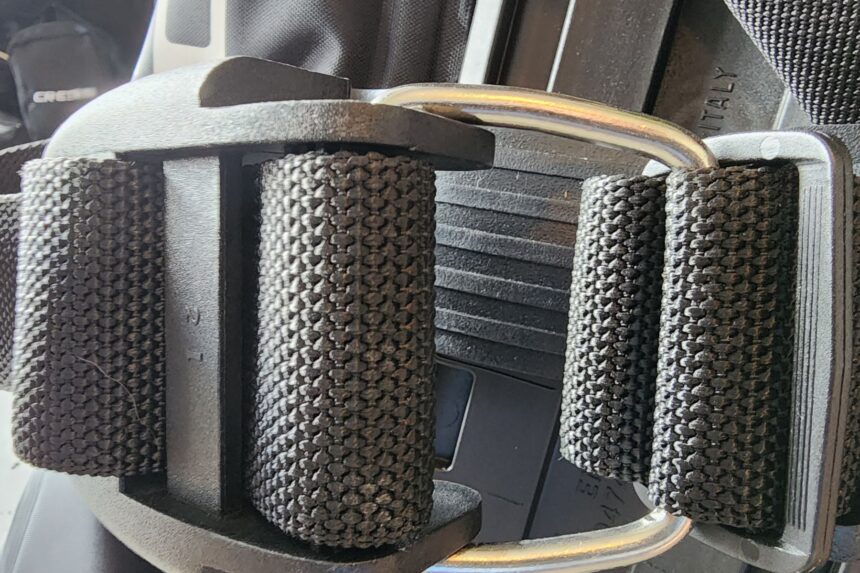 Close-up of the SEAC EQ-Pro single tank band threaded through its cam buckle