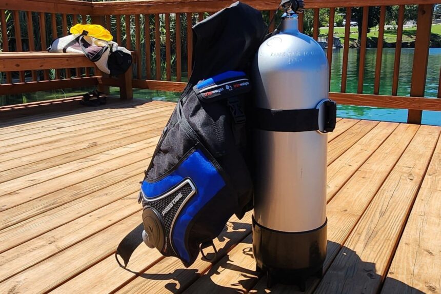 Mares Prestige SLS BCD strapped to a scuba tank standing on a wooden dock beside the lake
