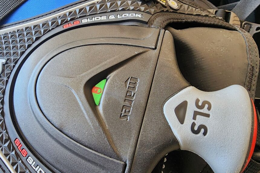 Close-up of a Mares Slide and Lock weight pocket seated in place with the green lock indicator showing