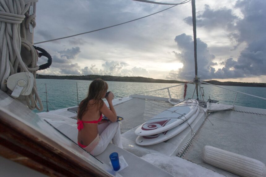 Guest relaxing on the bow at sunset aboard the Cat Ppalu