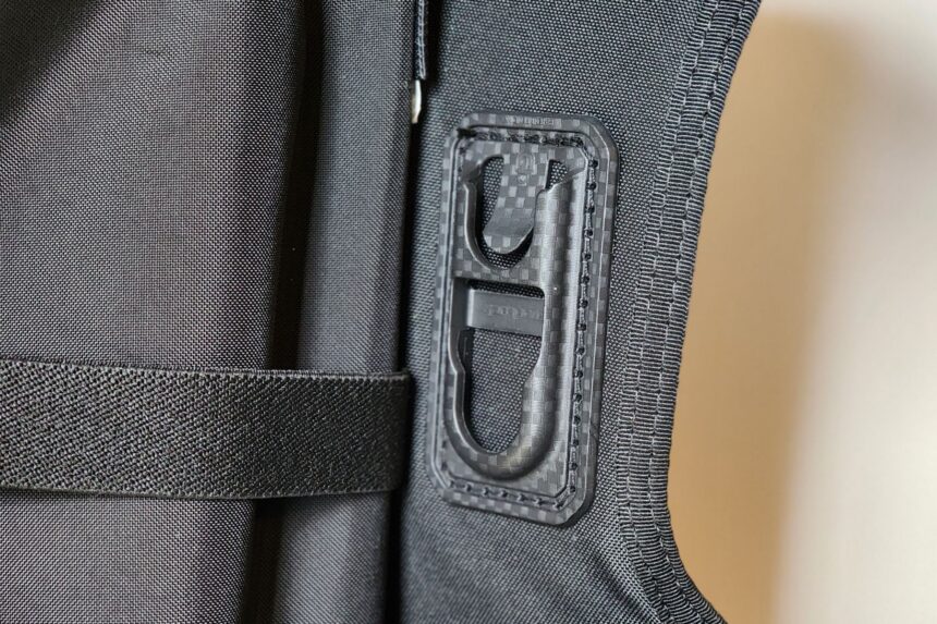 Black moulded clip stitched to the Aqualung Rogue fabric with webbing running past it