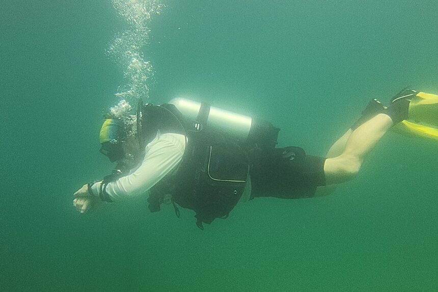 Our tester swimming in trim in the Genesis Origin BCD through green freshwater