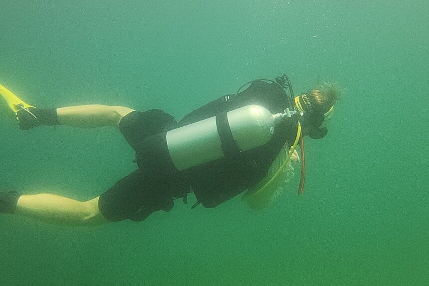 Our reviewer maneuvering underwater in the Genesis Origin on a green freshwater dive