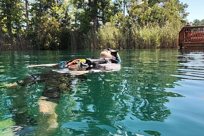 DIVEIN tester floating at the surface in the Genesis Origin beside a lakeside dock