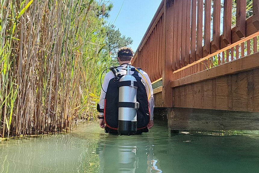 Our tester wading into a lake with the Hollis STS and its dual cam band tank rig on his back