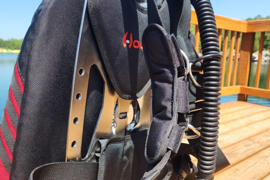 Close-up of the Hollis STS stainless backplate, harness webbing and corrugated inflator hose