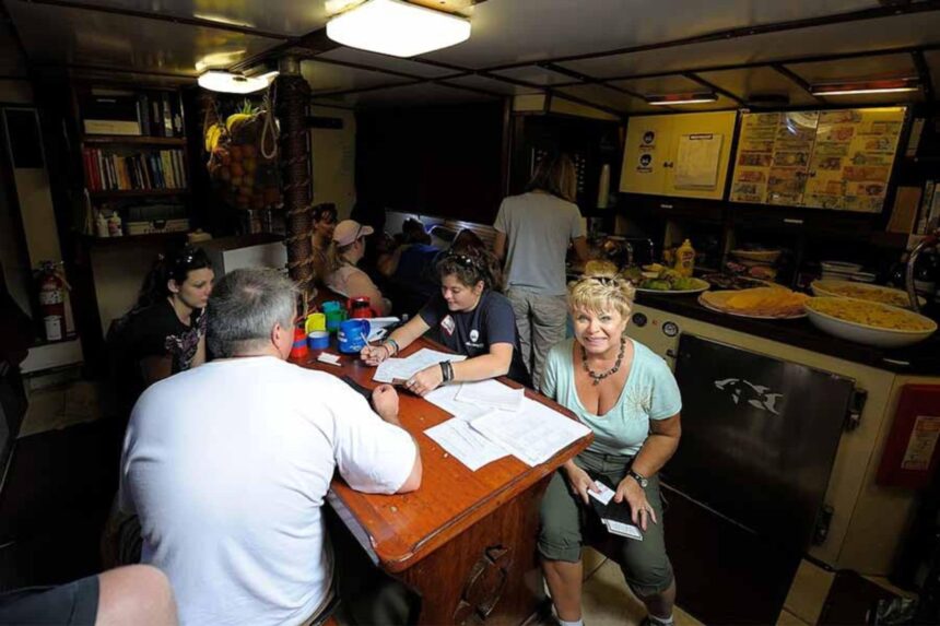 Crew and guests gathered around the check-in table below deck