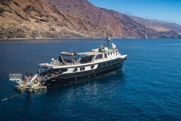Aerial view of the Nautilus UnderSea liveaboard anchored near a rocky coastline