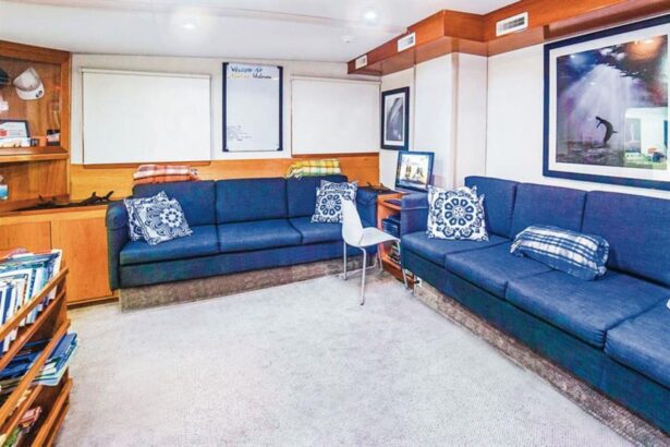 Lounge area with sofas, bookshelf and TV aboard the Nautilus UnderSea
