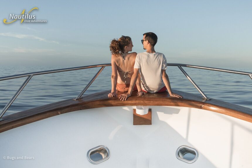 Couple sitting together on the bow watching the horizon