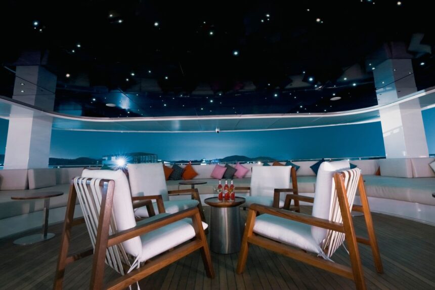 Wooden lounge chairs around a table on the M/Y White Pearl's starlit night deck