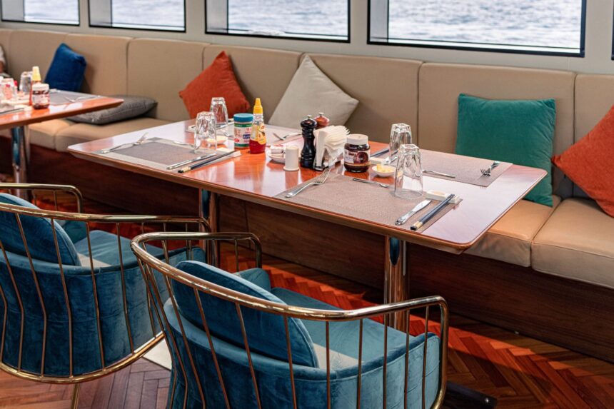 Set dining table with blue velvet chairs in the M/Y White Pearl's restaurant