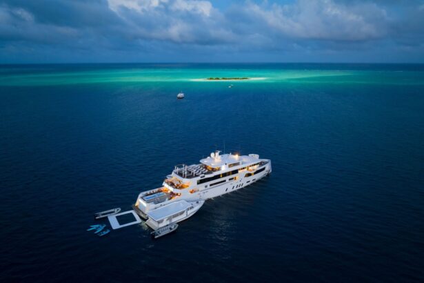 Aerial view of the White Pearl anchored near a small sandbar island in the Maldives at dusk