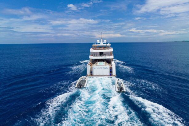 M/Y White Pearl underway seen from behind, name plate visible with two tenders in tow