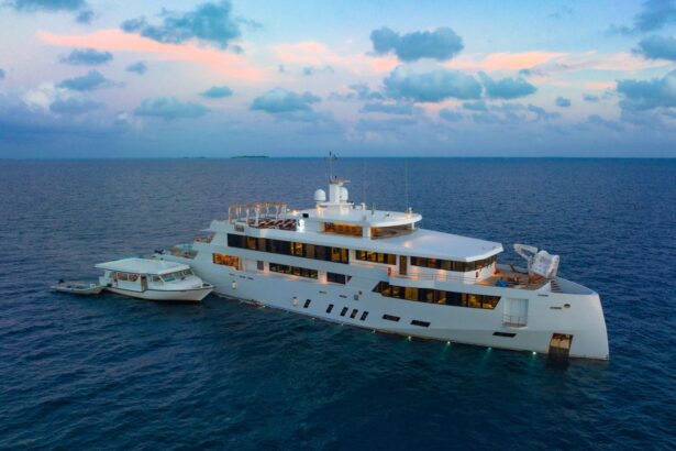 White Pearl at dusk with cabin lights glowing and a tender boat moored alongside
