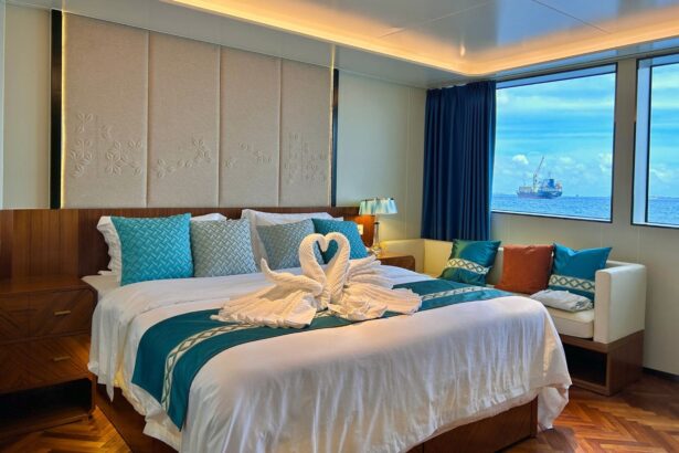 White Pearl stateroom with a king bed dressed in towel swans and sea views through the cabin windows