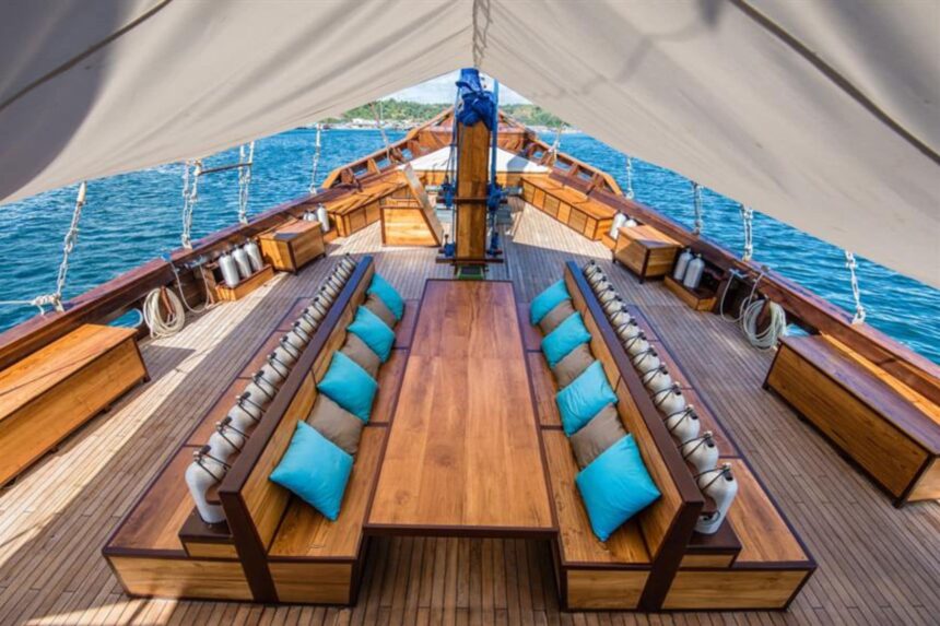 Wooden deck with teal cushioned bench seating on the Samambaia liveaboard's bow