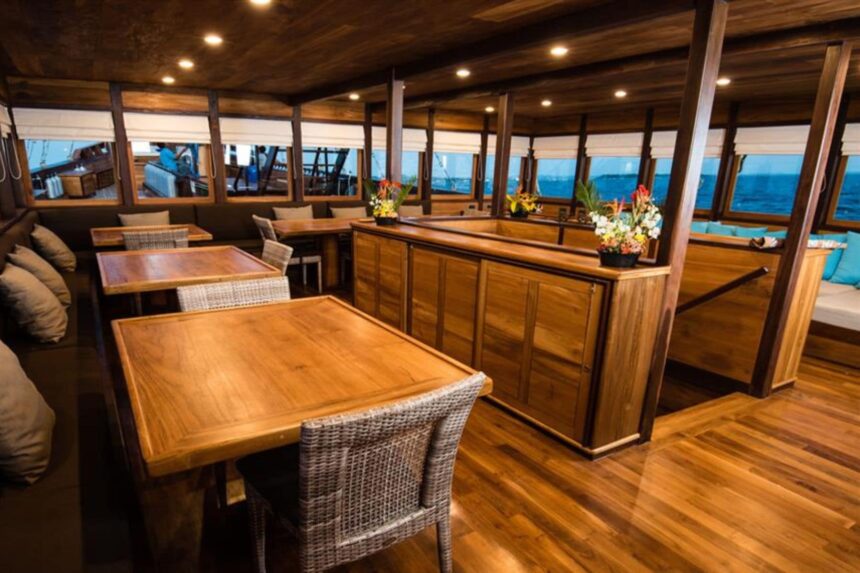 Wooden dining tables set for a meal aboard the Samambaia liveaboard