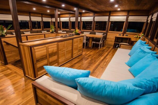 Indoor lounge with teal cushions in the Samambaia liveaboard's main salon at night