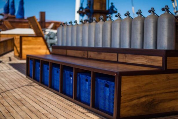 Scuba tanks stored above blue gear crates on the Samambaia's dive deck
