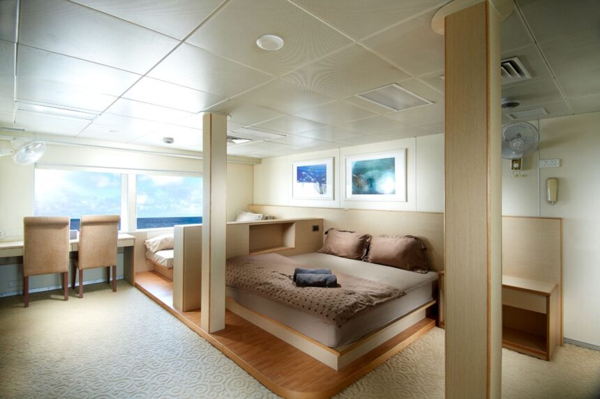 Spacious stateroom with king bed and desk aboard the Solitude Adventurer