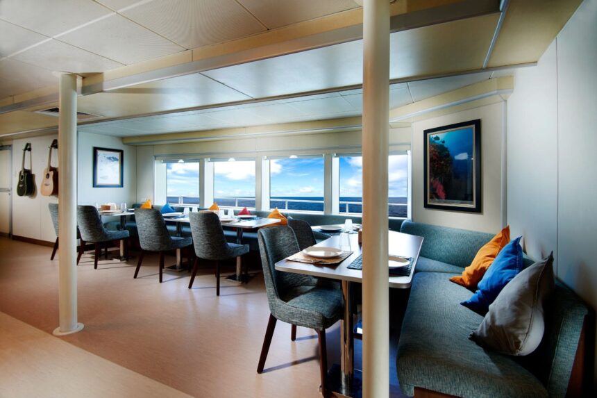 Indoor dining lounge with framed underwater photos aboard the Solitude Adventurer