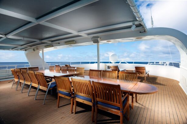 Covered outdoor dining table with wooden chairs on the Solitude Adventurer's deck