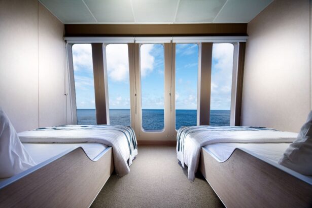 Twin beds facing ocean-view windows in a cabin aboard the Solitude Adventurer