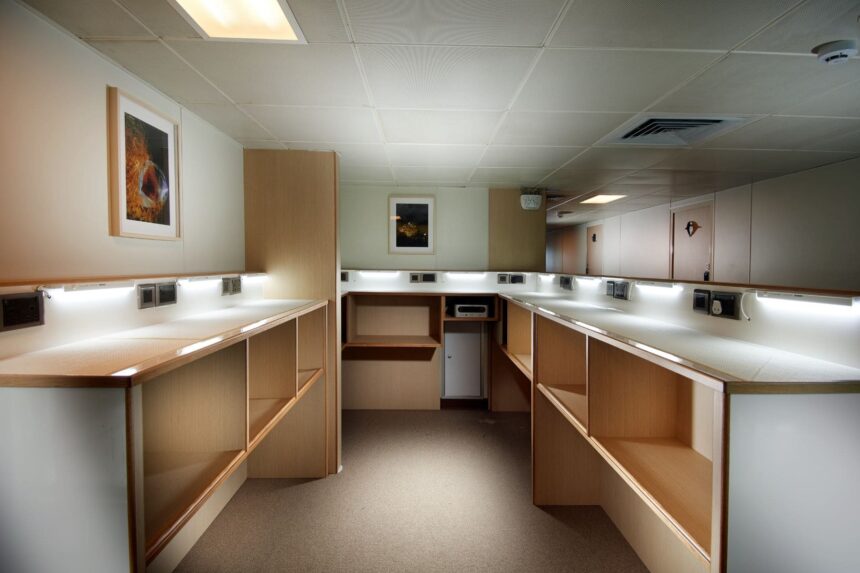 Built-in wooden counters and storage line a corridor aboard the Solitude Adventurer
