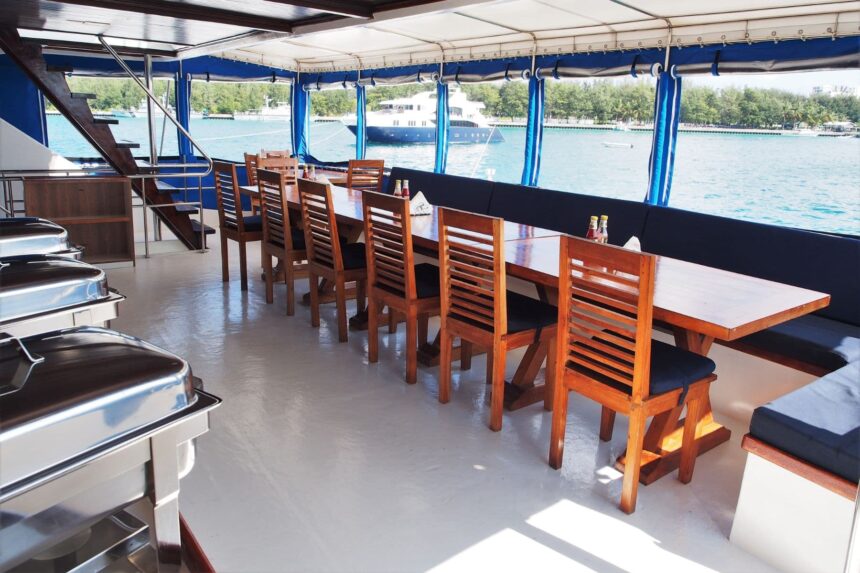 A well-stocked bar with liquor bottles and stools aboard the Emperor Voyager