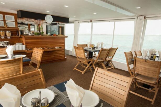 Dining area with wooden bar and table seating aboard the All Star Avalon