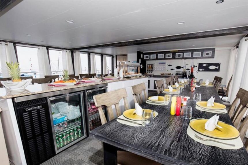 Dining room with yellow place settings and a drinks fridge aboard the Avalon fleet