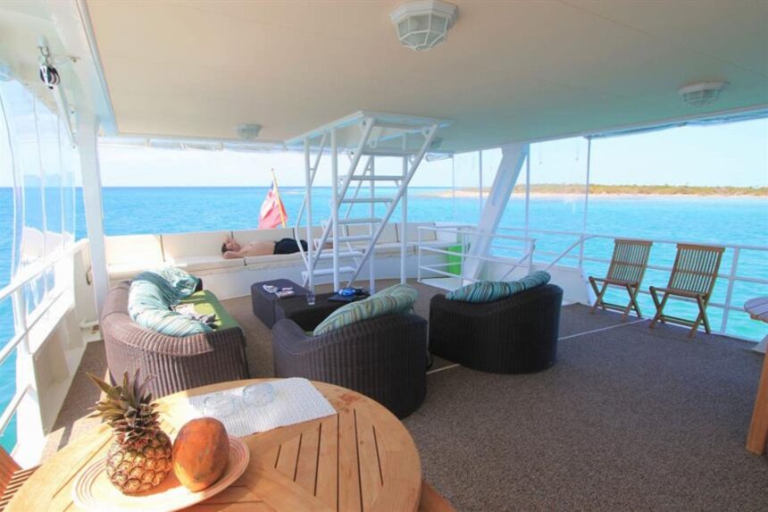 Shaded lounge seating on the upper deck with fruit on a table